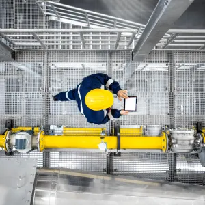 Worker with tablet in factory from above.